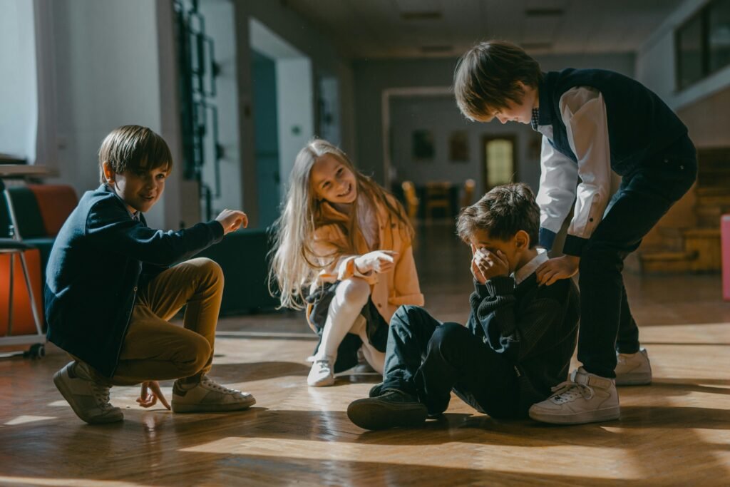 Four kids engaged in a playful or bullying encounter inside a school.